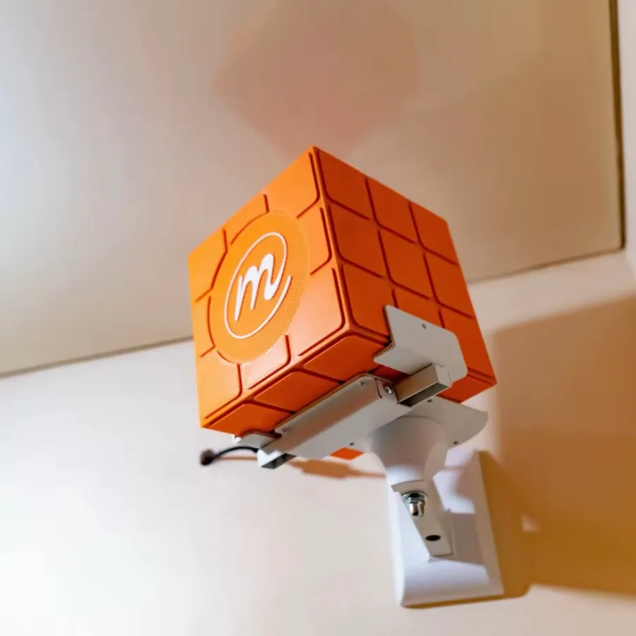 Orange AGOGO speaker installed on a wall mount inside Merci Internet